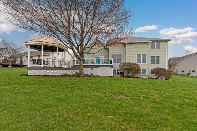 back of property with a lawn, a wooden deck, and a gazebo