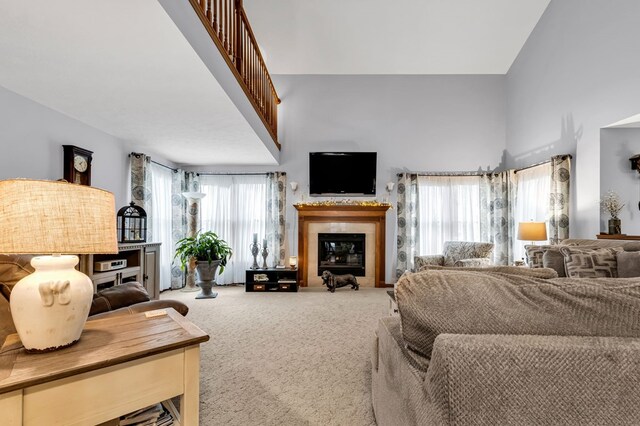 carpeted living area with a high ceiling and a tile fireplace