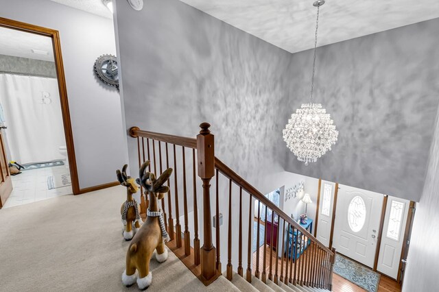carpeted entryway with a chandelier