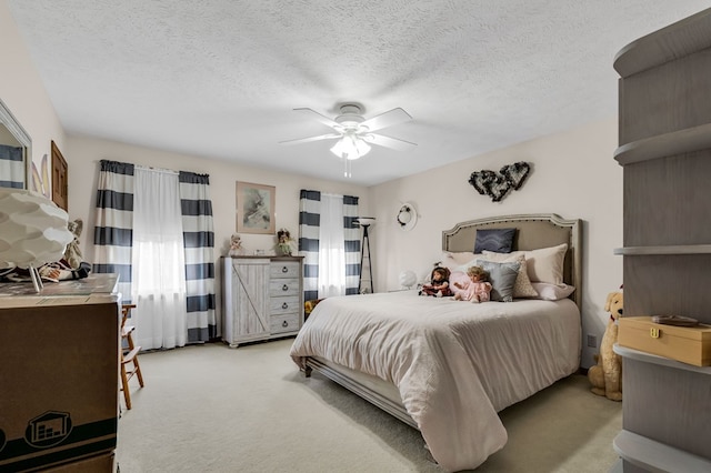 bedroom featuring a textured ceiling, ceiling fan, and light colored carpet