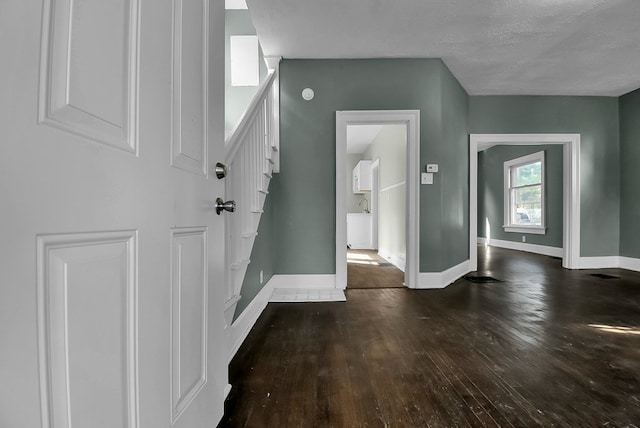 foyer entrance with visible vents, baseboards, hardwood / wood-style flooring, stairway, and a textured ceiling