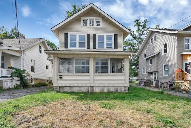 american foursquare style home with a sunroom, fence, and a front yard