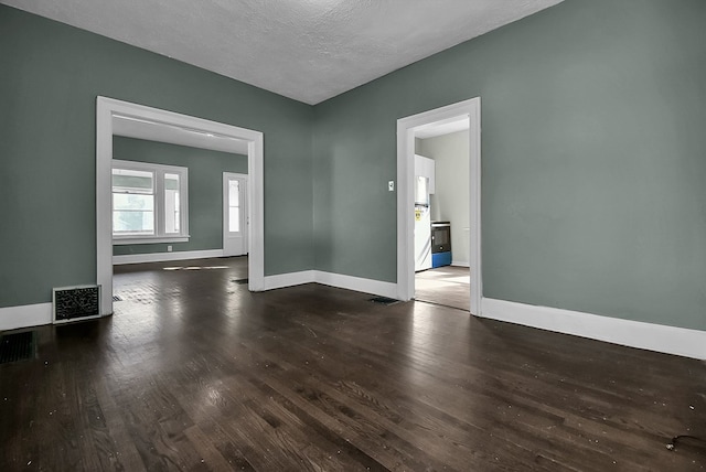 unfurnished room with visible vents, a textured ceiling, baseboards, and wood finished floors