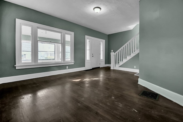 entrance foyer featuring stairway, wood finished floors, visible vents, and baseboards