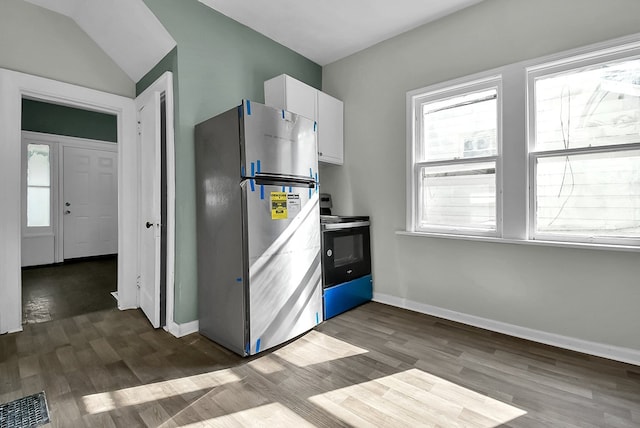 kitchen with electric range, white cabinets, dark wood finished floors, and freestanding refrigerator