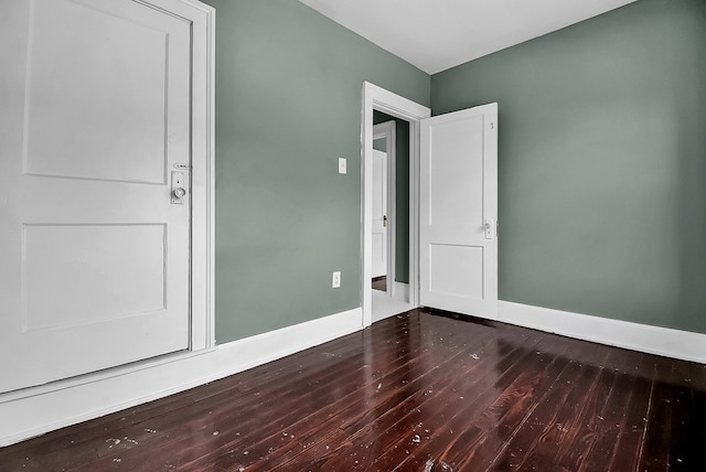 empty room with wood finished floors and baseboards