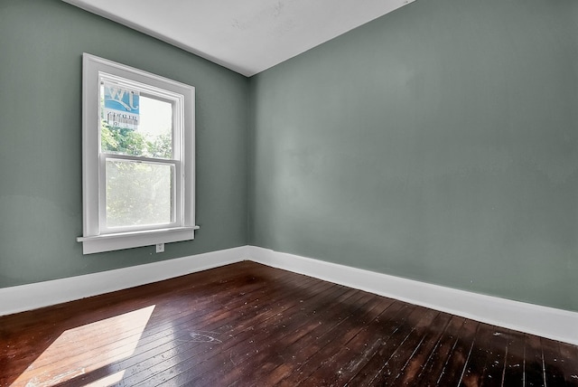 empty room with dark wood-style flooring and baseboards