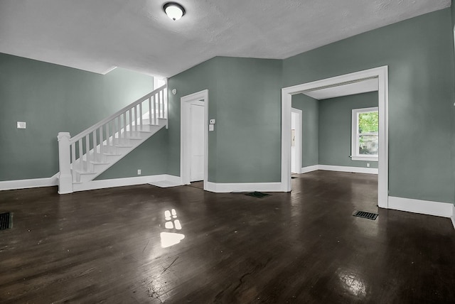 unfurnished living room with baseboards, stairs, visible vents, and wood finished floors