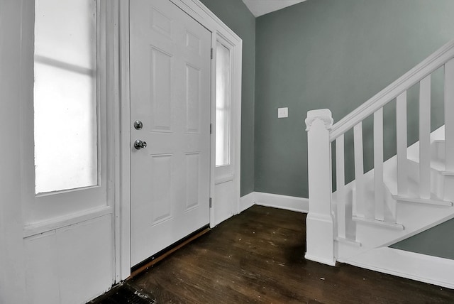 foyer with dark wood-type flooring, stairway, and baseboards