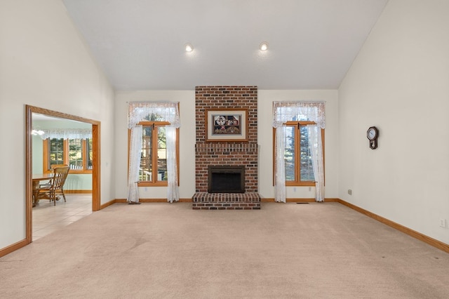 unfurnished living room with baseboards, a fireplace, high vaulted ceiling, and carpet