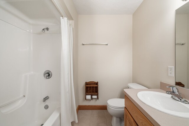 bathroom with a textured ceiling, baseboards, toilet, tile patterned floors, and vanity
