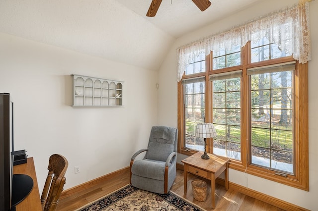 living area featuring wood finished floors, plenty of natural light, vaulted ceiling, and ceiling fan