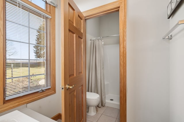 bathroom featuring toilet, tile patterned floors, and a shower stall