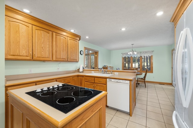 kitchen with white appliances, an inviting chandelier, light tile patterned floors, a sink, and a peninsula