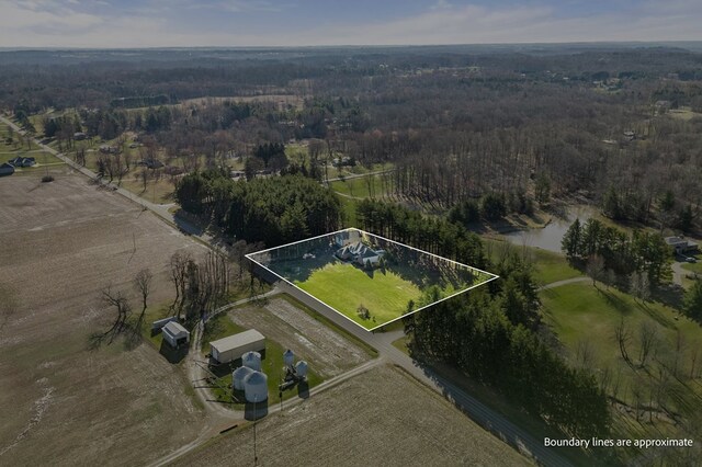 birds eye view of property with a view of trees and a rural view