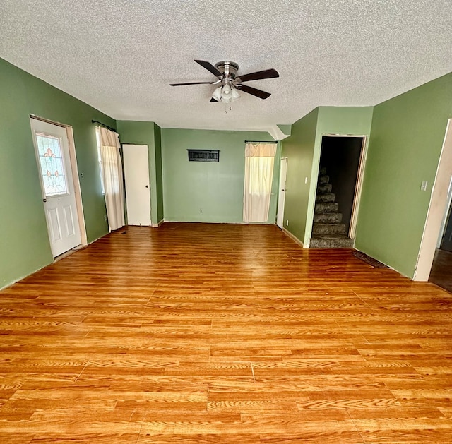 unfurnished living room featuring a textured ceiling, light hardwood / wood-style floors, and ceiling fan