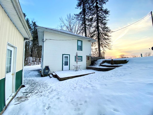 snow covered house with a wooden deck