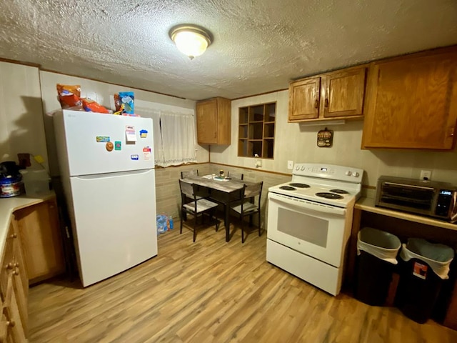 kitchen with white appliances, light hardwood / wood-style floors, and a textured ceiling