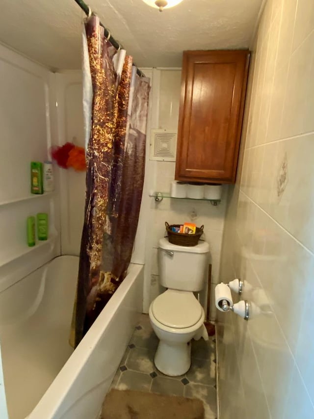 bathroom featuring shower / bathtub combination with curtain, a textured ceiling, and toilet