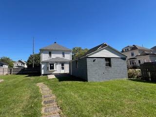 back of property featuring an outbuilding and a yard