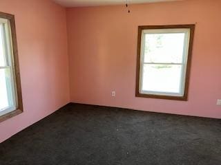 spare room with dark colored carpet