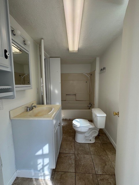 full bath with toilet, a textured ceiling, tile patterned flooring, shower / bath combination, and vanity