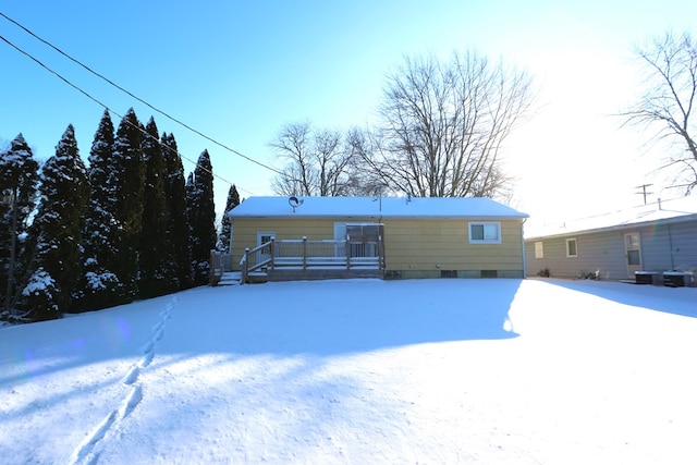 snow covered back of property featuring central AC unit