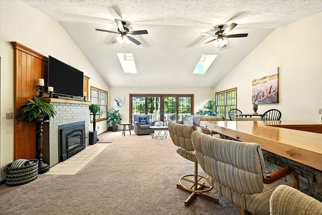 415 Lakeshore Rd, Ashland, OH 44805 - living room featuring a skylight, light colored carpet, a ceiling fan, a brick fireplace, and high vaulted ceiling