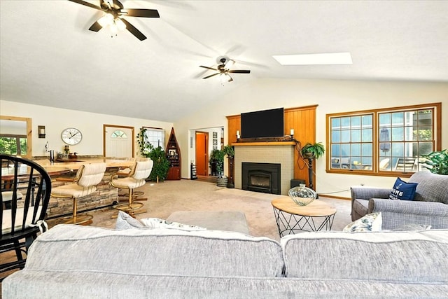 415 Lakeshore Rd, Ashland, OH 44805 - carpeted living area with vaulted ceiling, ceiling fan, a brick fireplace, and a skylight