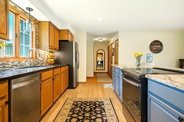415 Lakeshore Rd, Ashland, OH 44805 - kitchen featuring stainless steel appliances, light wood-style flooring, backsplash, brown cabinets, and dark stone countertops
