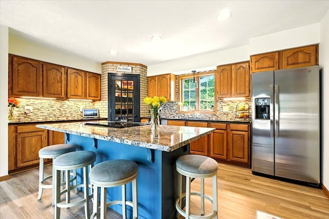 415 Lakeshore Rd, Ashland, OH 44805 - kitchen with stainless steel fridge, black electric cooktop, brown cabinetry, and recessed lighting