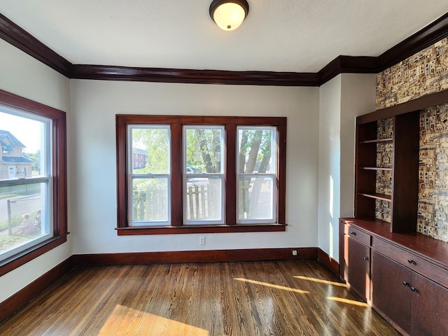 unfurnished dining area with dark hardwood / wood-style floors and ornamental molding