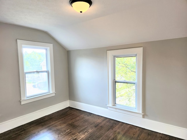 bonus room with vaulted ceiling and dark wood-type flooring