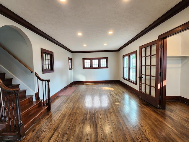 unfurnished room with a textured ceiling, dark hardwood / wood-style flooring, and crown molding