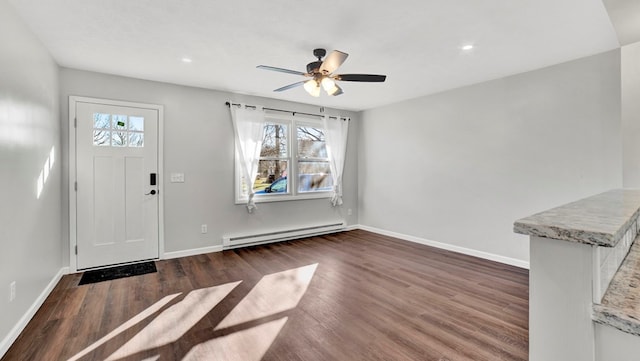 foyer entrance with dark hardwood / wood-style floors, ceiling fan, and a baseboard heating unit