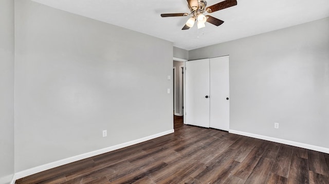 unfurnished bedroom with dark hardwood / wood-style flooring, ceiling fan, and a closet