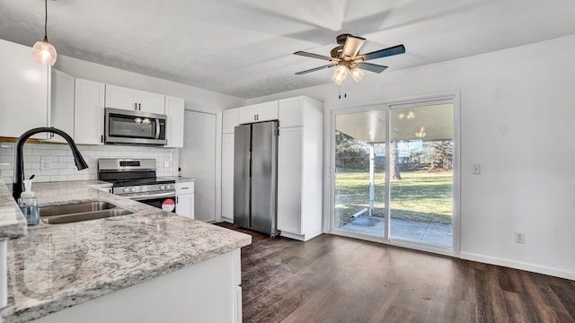 kitchen with white cabinetry, sink, decorative light fixtures, and appliances with stainless steel finishes