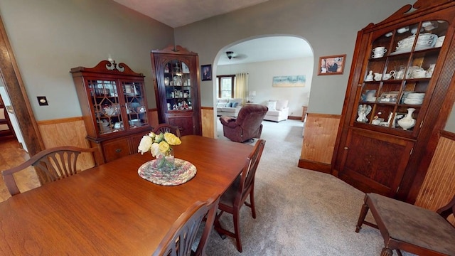 528 Maplewood St, Willard, OH 44890 - dining space featuring a wainscoted wall, arched walkways, wood walls, and carpet flooring