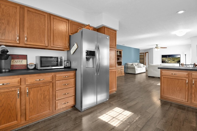 kitchen featuring dark countertops, dark wood-style floors, stainless steel appliances, and brown cabinetry