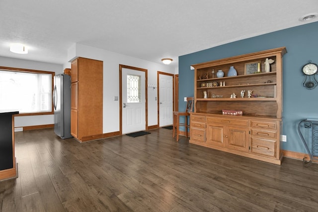 foyer with visible vents, baseboards, and dark wood-style flooring