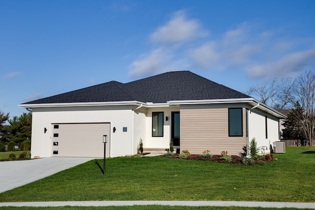 view of front of house with central air condition unit, a front yard, and a garage