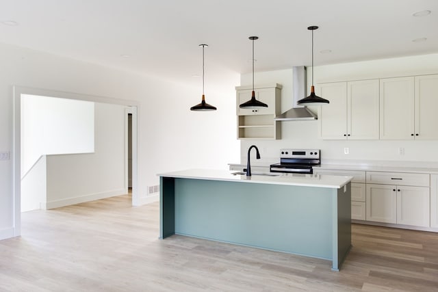 kitchen with sink, hanging light fixtures, an island with sink, light hardwood / wood-style floors, and stainless steel range with electric stovetop