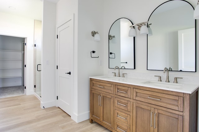 bathroom featuring hardwood / wood-style flooring, vanity, and a shower with door