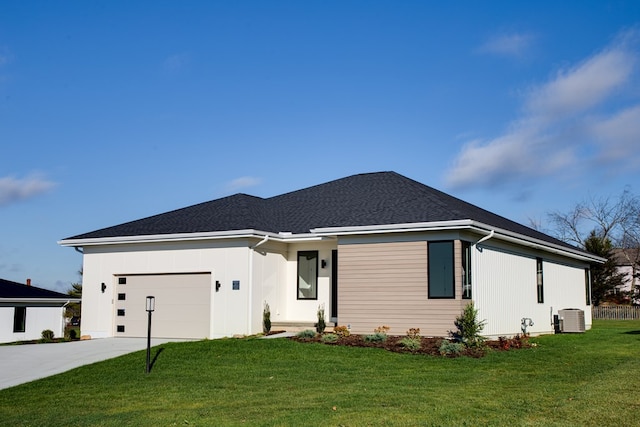 view of front of house featuring a garage, central air condition unit, and a front yard