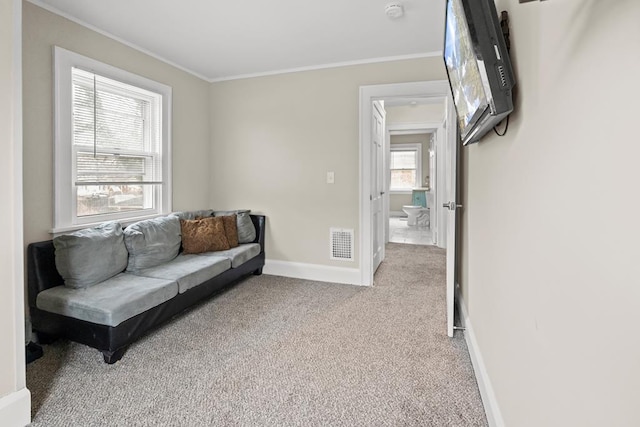 carpeted living room featuring visible vents, crown molding, and baseboards