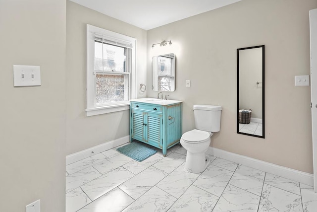 bathroom featuring marble finish floor, vanity, toilet, and baseboards