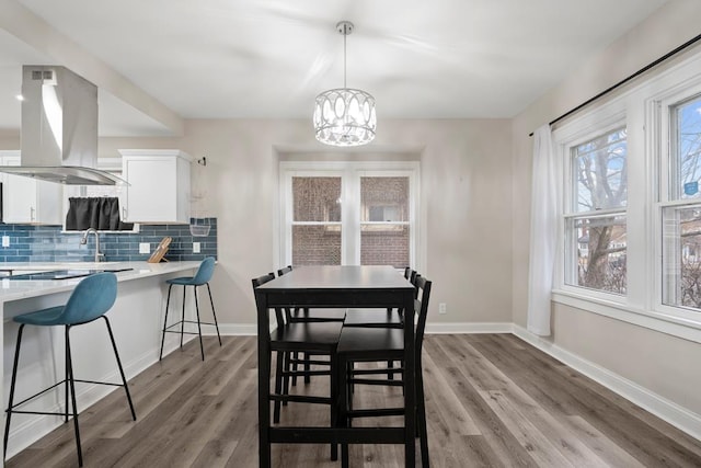 dining area featuring baseboards, a notable chandelier, and light wood-style floors