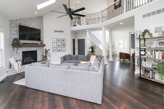 122 Woodside Blvd, Lexington, OH 44904 - living area with high vaulted ceiling, a stone fireplace, a ceiling fan, wood finished floors, and decorative columns