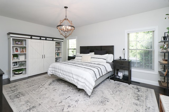 122 Woodside Blvd, Lexington, OH 44904 - bedroom featuring a chandelier, wood finished floors, baseboards, and a barn door
