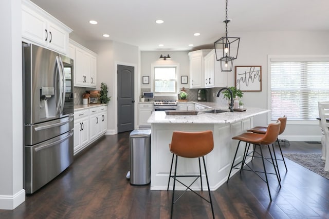 122 Woodside Blvd, Lexington, OH 44904 - kitchen with stainless steel appliances, a sink, a peninsula, decorative backsplash, and recessed lighting